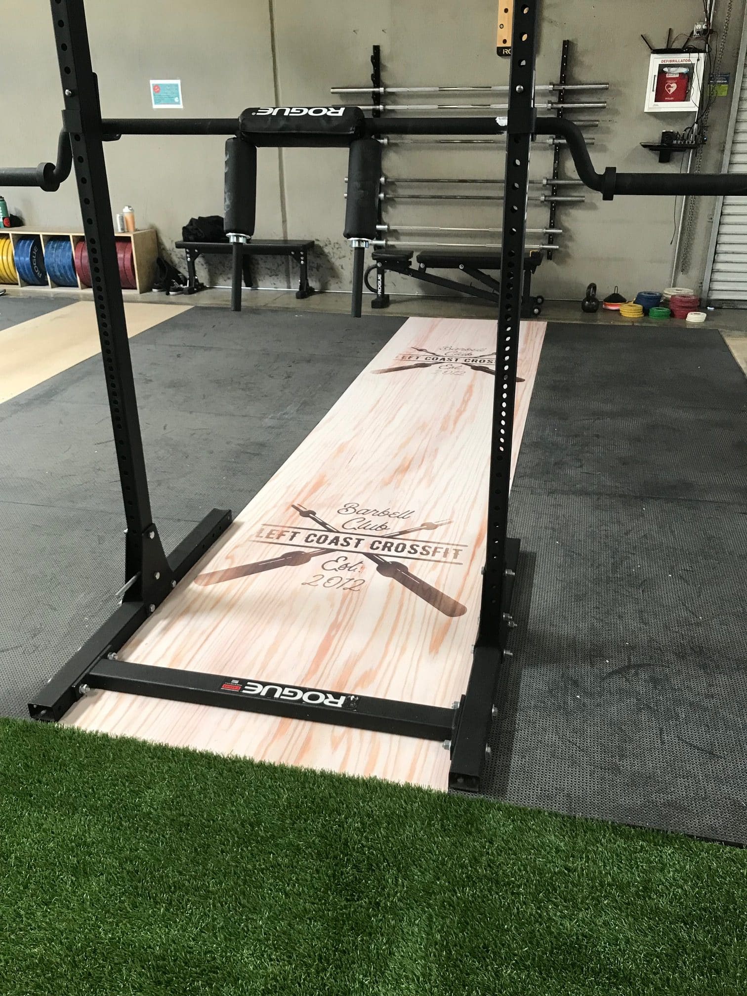 Rotated view of event signage featuring gym wall branding and podium