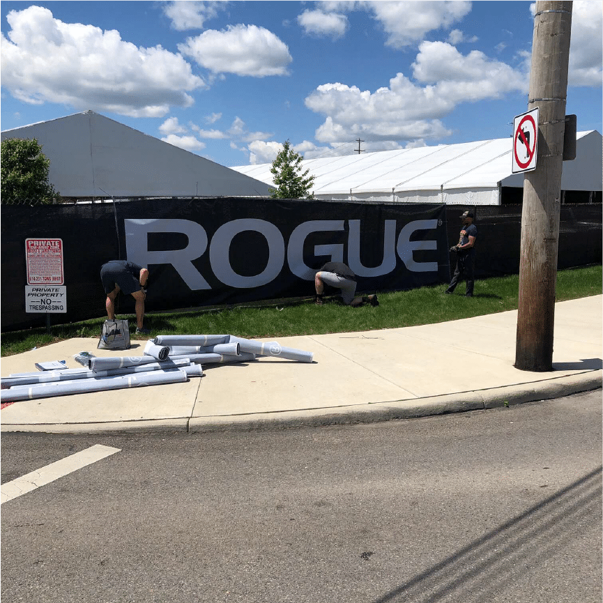 Wind-resistant mesh banner minimizing displacement in breezy conditions.